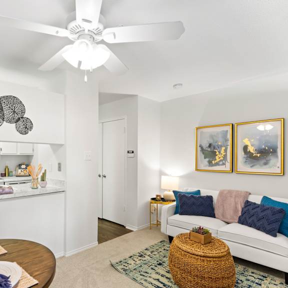 a living room with a white couch and a ceiling fan.