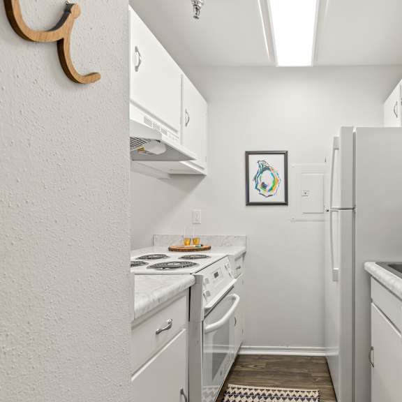 a small kitchen with white appliances and cabinets.