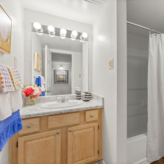 a bathroom with a toilet, sink, and shower.