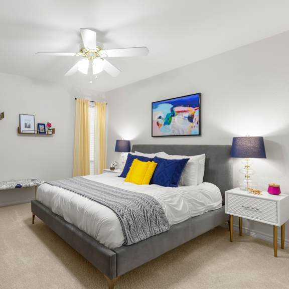 a bedroom with a bed, nightstand, and a painting on the wall.