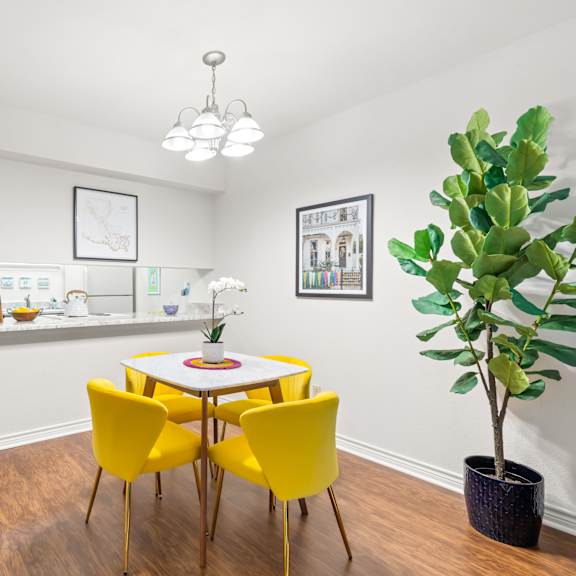 a room with a white table and yellow chairs.