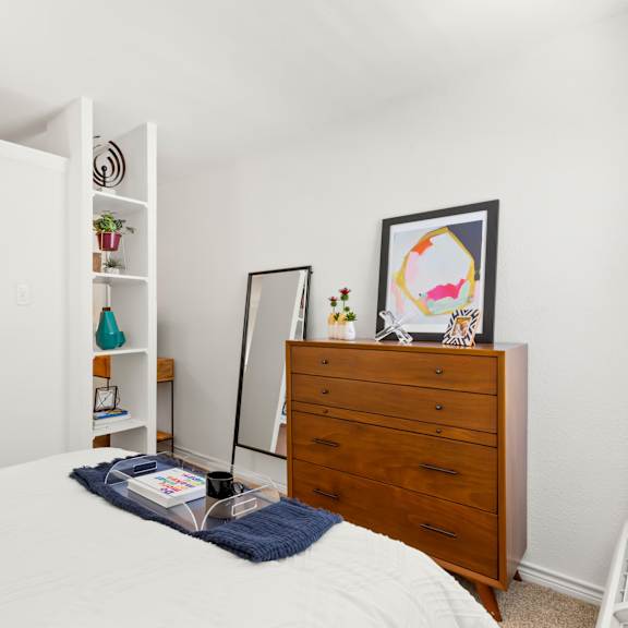 a bedroom with a bed, a dresser, and a mirror.