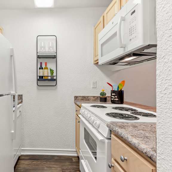 a small kitchen with a white refrigerator and a white stove.