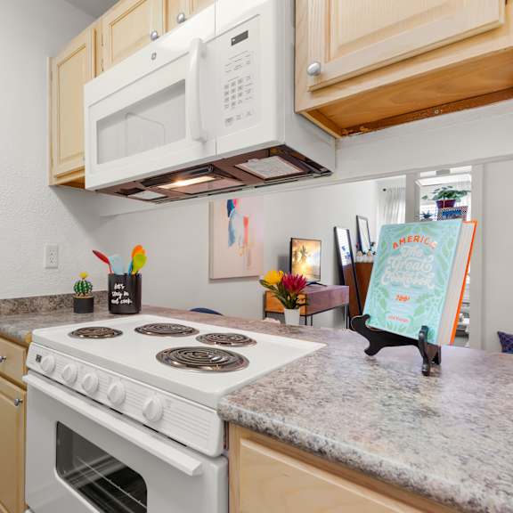 a kitchen with a white stove top oven and a white microwave above it.