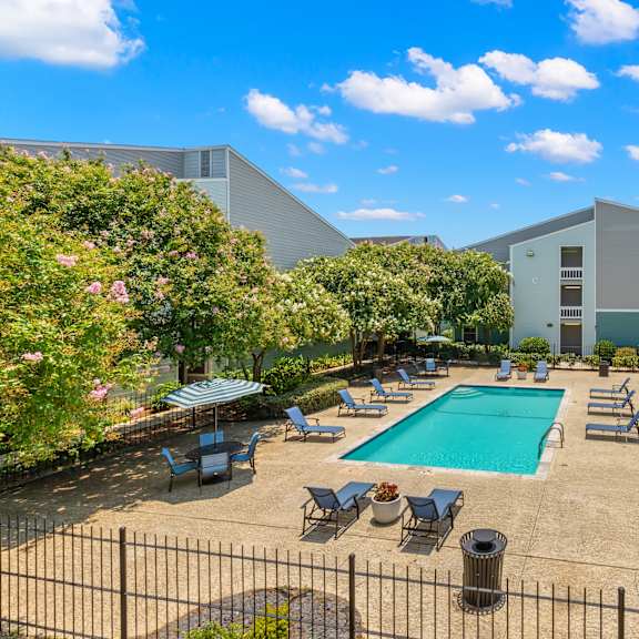 a pool surrounded by chairs and umbrellas.