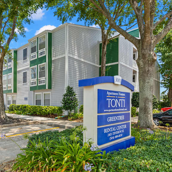 a sign for apartment home by tonti in front of a building.