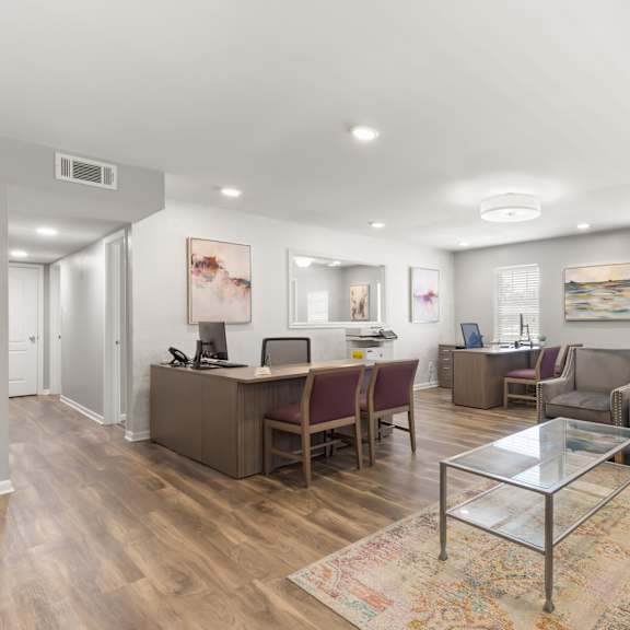 a spacious living room with a glass coffee table and a variety of seating options.