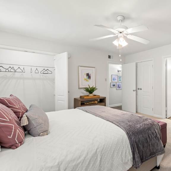 a bedroom with a bed, a chair, and a mirror on the wall.