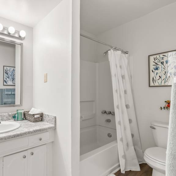 a white bathroom with a vanity and a shower.