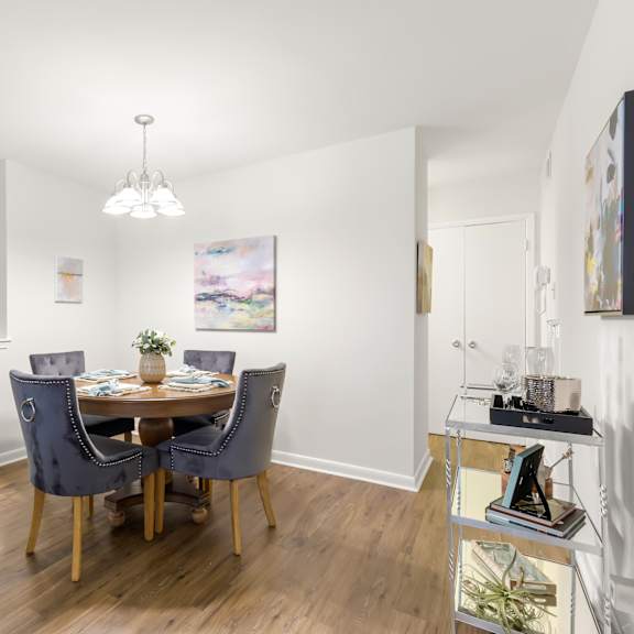 a dining room with a table set for two and a painting on the wall.