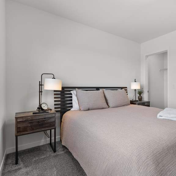 Thumbnail 12 of 21 Bedroom with a bed and a nightstand with two lamps at Yellowstone Landing, Belgrade