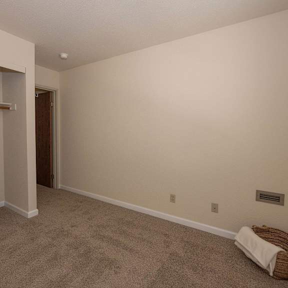 a room with a carpeted floor and a closet at hilltop commons senior living, grass valley california