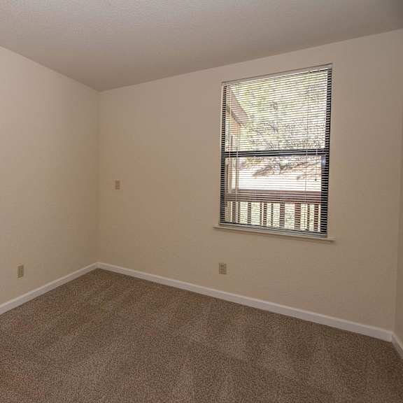 an empty room with carpet and a window at hilltop commons senior living, california