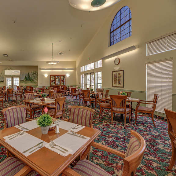 a large dining room with tables and chairs at hilltop commons senior living, grass valley california