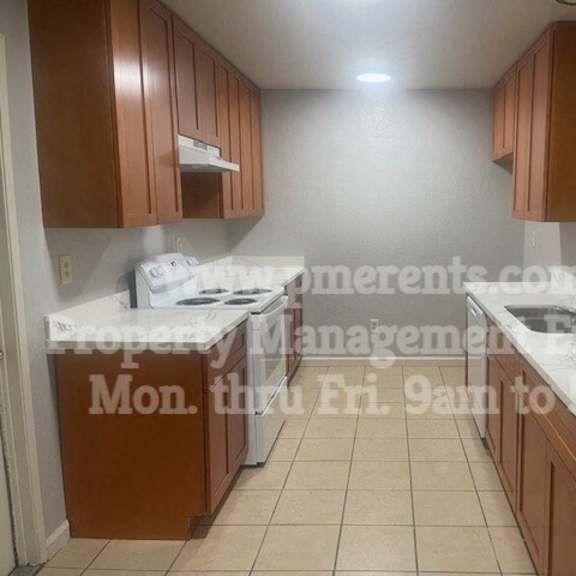 a kitchen with marble counter tops and wooden cabinets