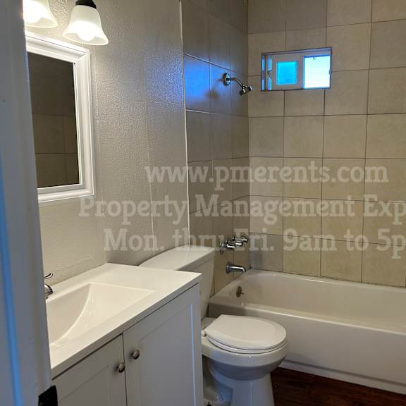 a white bathroom with a toilet, sink, and bathtub.