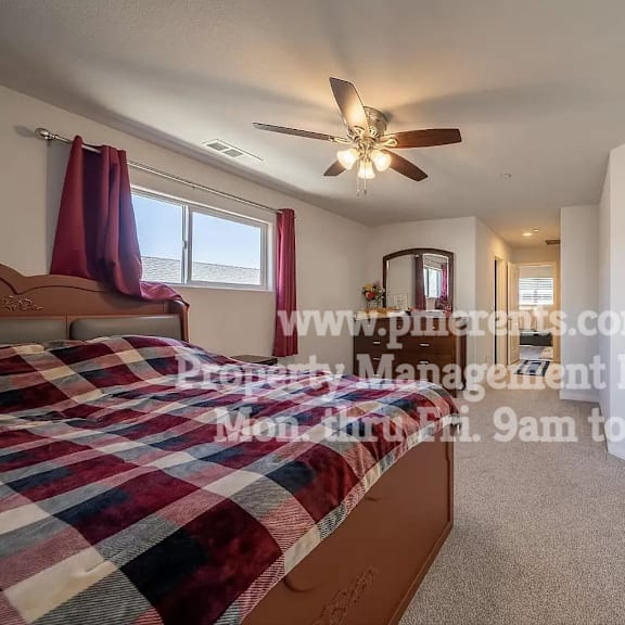 a bedroom with a bed and a ceiling fan