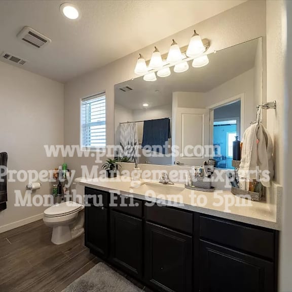 a bathroom with a toilet and a sink and a mirror