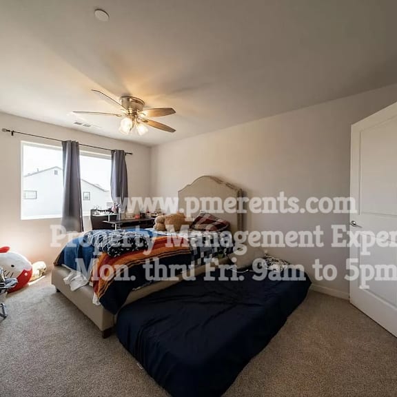 a bedroom with a bed and a ceiling fan