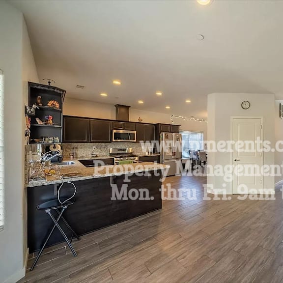 a large living room with a kitchen and a door to a patio