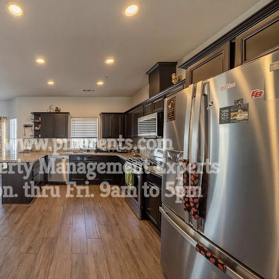 a kitchen with stainless steel appliances and wood floors