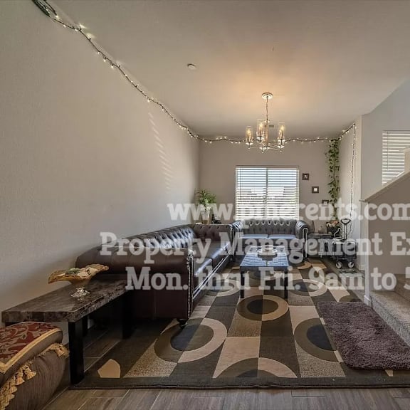 a living room with a staircase and a dining room