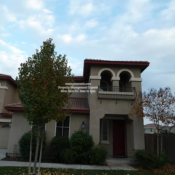 a house with a red door and a balcony.