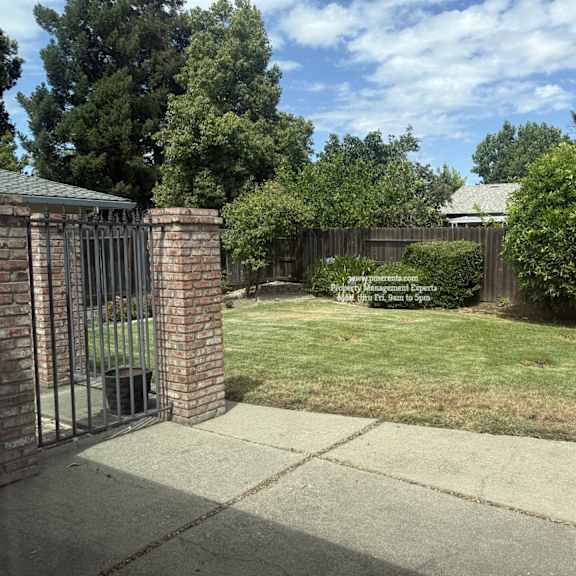 a backyard with a fence and a sign that says