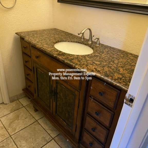 a bathroom with a granite countertop and a sink.