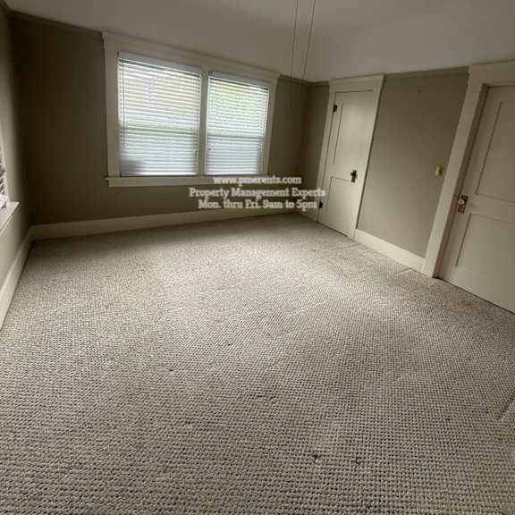 a room with a ceiling fan and carpeted floor.
