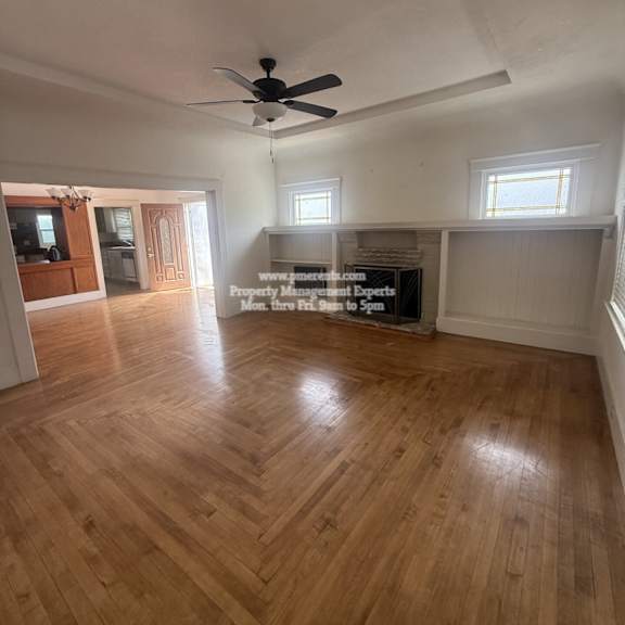 a room with wooden flooring and a ceiling fan.