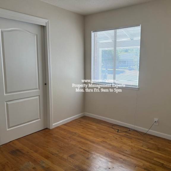 a room with a door and a window with blinds.