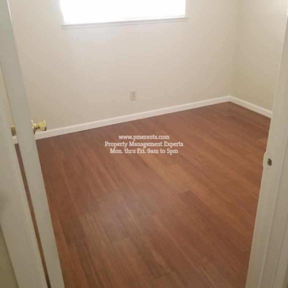 a room with a wooden floor and a sign on the wall.