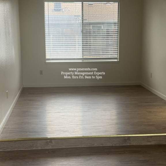 a room with a window and a fan on the ceiling.