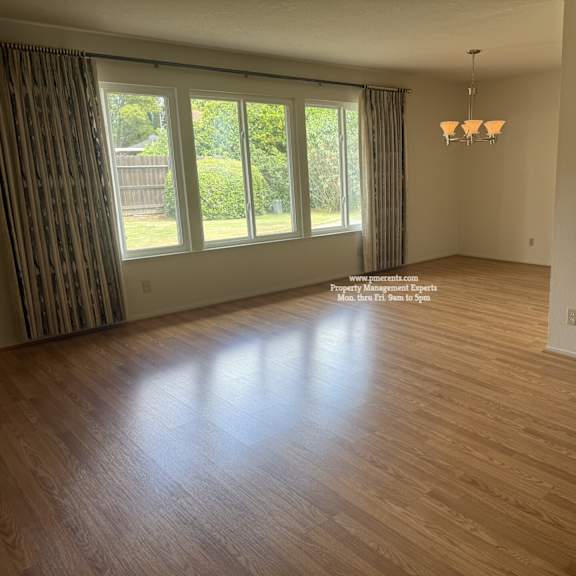 a room with wooden flooring and a chandelier.