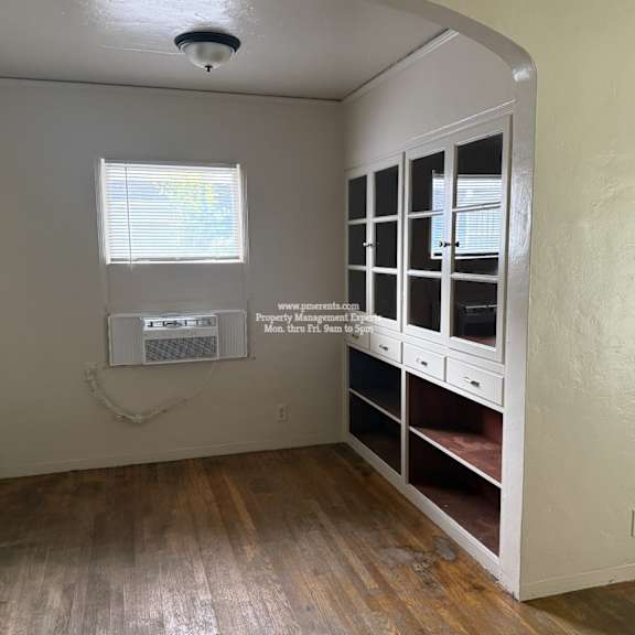 a room with a window and a cabinet with drawers.