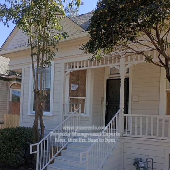 a house with a porch and a tree in front.