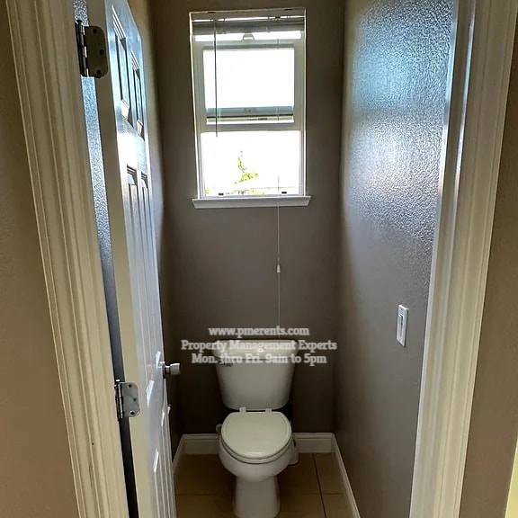 a small bathroom with a toilet and a window.