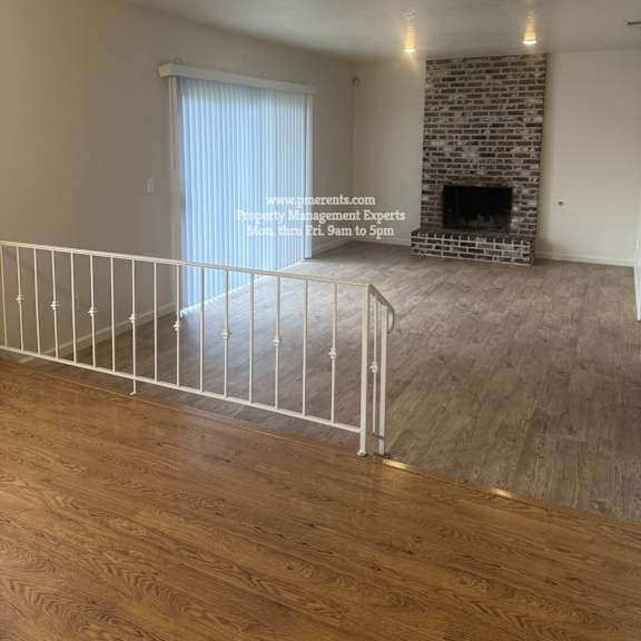 a living room with a fireplace and a railing.