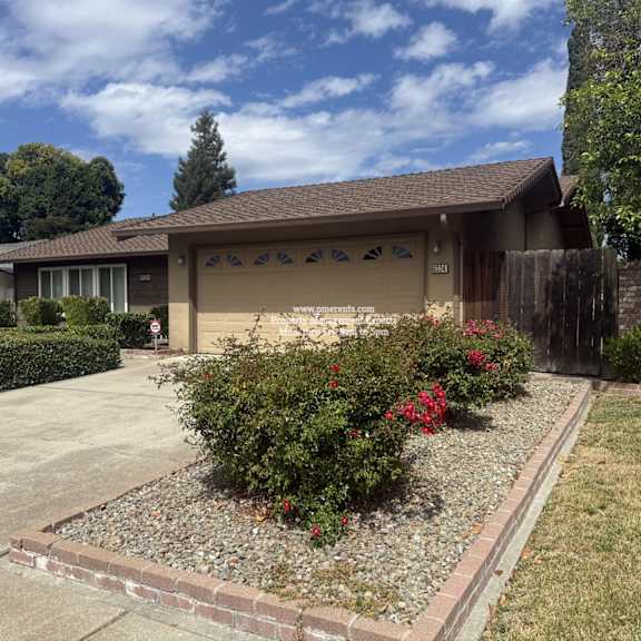 a house with a brown roof and a garden in front.