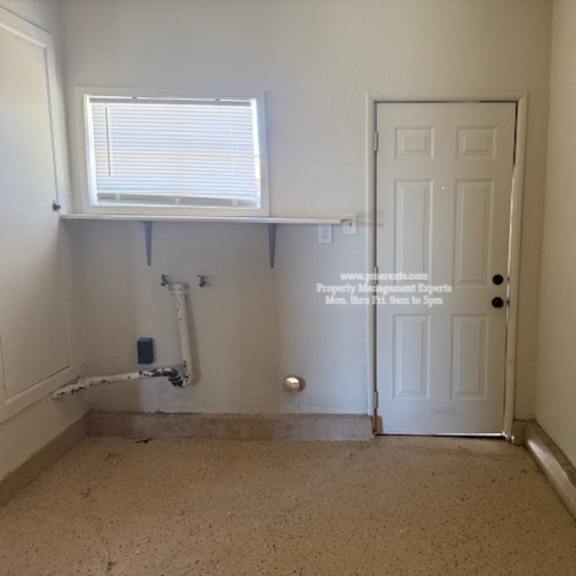 a room with a door, window, and pipes.