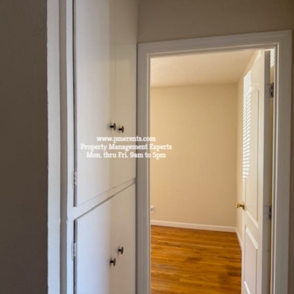 a hallway with a door on the left and a window on the right.