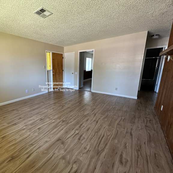 a room with wooden flooring and a white ceiling.