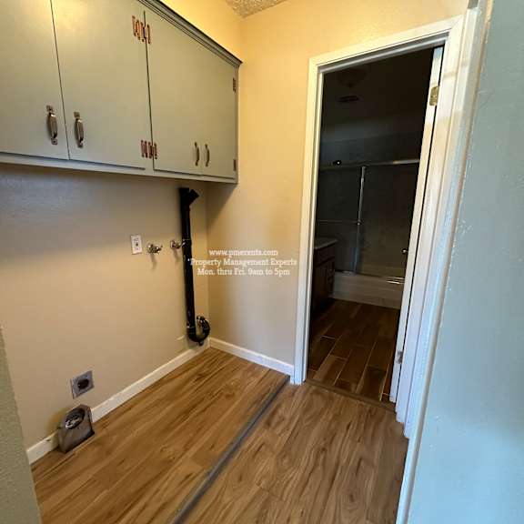 a room with a white door and a wall with a pipe.
