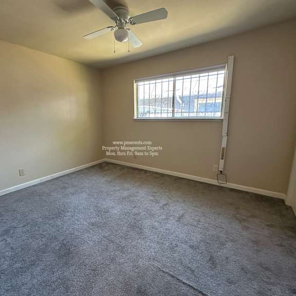 a room with a ceiling fan and a window.