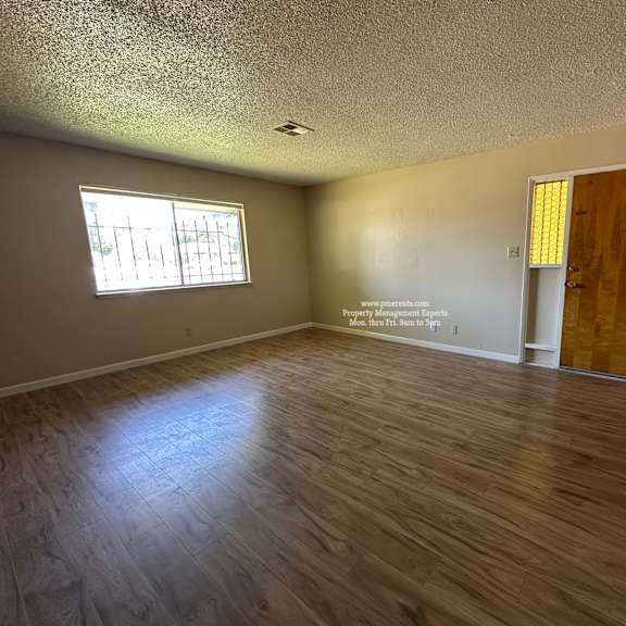 a room with wooden flooring and a door on the right.
