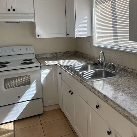 a kitchen with a white stove and white cabinets.