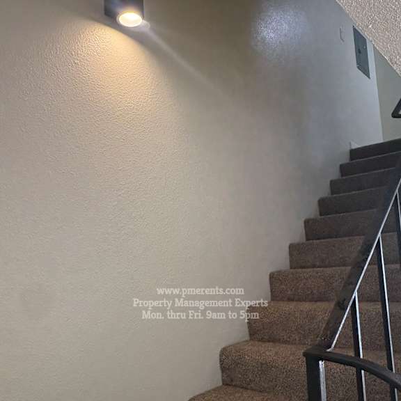 a staircase with a light on the wall.
