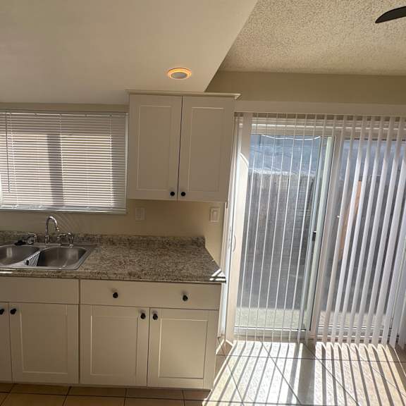 a kitchen with white cabinets and a granite countertop.