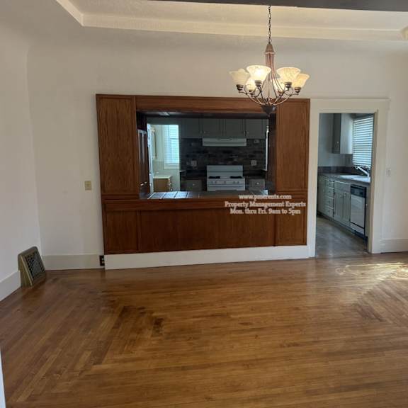 a room with wooden floors and a chandelier.